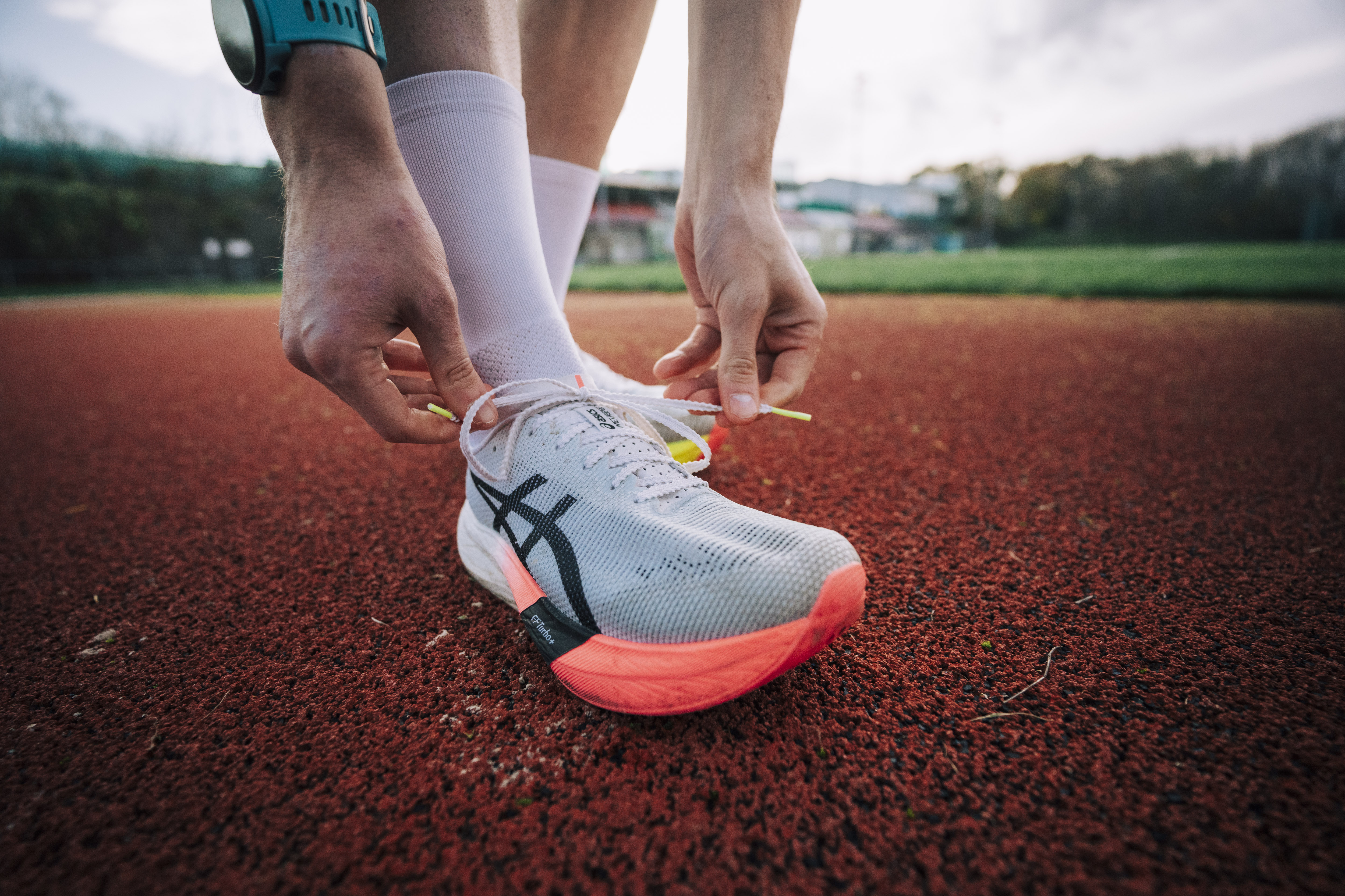 An athlete tying their running shoes before training.